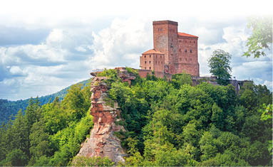 Hoch ber den Pf lzer Wald thront die Burg Trifels auf rotem Sandstein-Felsen.