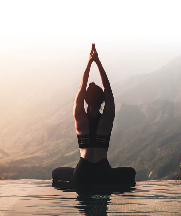 Beautiful Attractive Asian woman practice yoga Lotus pose on the pool above the Mountain peak in the morning in front of beautiful nature views,Feel so comfortable and relax in holiday,Warm tone