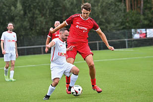 Das Bild zeigt eine gro e Gruppe fr hlicher Menschen auf einem Sportplatz. Sie haben sich zur bergabe eines symbolischen Spendenschecks von 10.000 € versammelt, gestiftet von LOTTO Rheinland-Pfalz.    Im Vordergrund steht ein gelbes „LOTTO Elf“-Schild. In der Mitte wird der Scheck hochgehalten – die Spende geht an ein Projekt zur Unterst tzung von Waisenkindern in Ruanda, wie aus der Aufschrift hervorgeht.    Die Gruppe besteht aus Sportlern (erkennbar an den roten „LOTTO Elf“-Trikots), Organisatoren, Unterst tzern und G sten – teils in Alltagskleidung, teils in thematisch passenden Shirts (z. B. „Rwanda“). Die Stimmung ist herzlich, engagiert und gemeinschaftlich – ein starkes Zeichen f r soziales Engagement durch Sport.