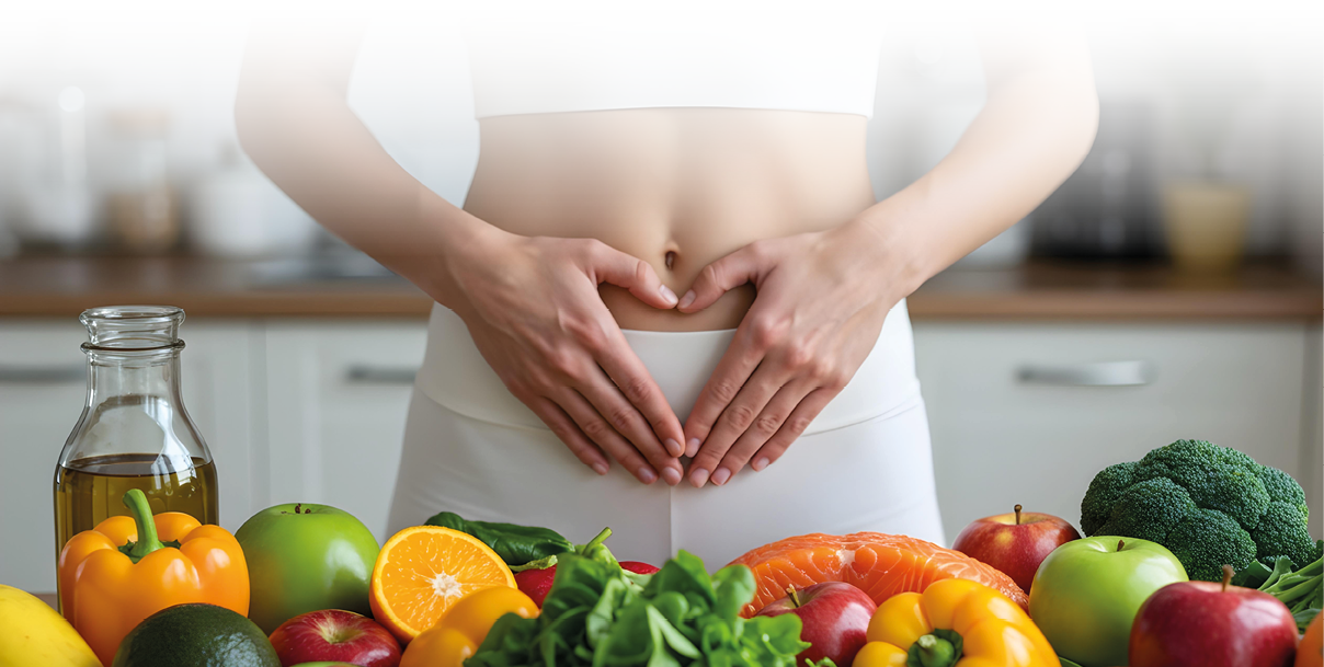 Auf dem Bild sieht man eine Person, die ihre H nde in Herzform auf den Bauch legt – ein typisches Motiv, um Darmgesundheit, Verdauung oder ganzheitliches Wohlbefinden darzustellen.   Im Vordergrund liegt eine Auswahl an frischen, gesunden Lebensmitteln wie Paprika,  pfel, Orangen, Brokkoli, Spinat, Lachs und Oliven l. Damit vermittelt das Bild die Botschaft, dass eine ausgewogene Ern hrung entscheidend f r einen gesunden Darm und damit f r das allgemeine Wohlbefinden ist.