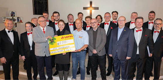 In festlicher Atmosph re pr sentieren Vertreterinnen und Vertreter von Lotto Rheinland-Pfalz und dem Arbeiter-Samariter-Bund gemeinsam mit den Mainzer Hofs ngern einen symbolischen Spendenscheck in H he von 8.000 Euro f r den ASB-W nschewagen Rheinland-Pfalz. Das Foto zeigt die fr hliche Gruppe in einem stimmungsvoll beleuchteten Kirchenraum – ein Moment voller Dankbarkeit und Engagement f r einen guten Zweck. Die Spende unterst tzt den W nschewagen dabei, schwerkranken Menschen letzte Herzensw nsche zu erf llen.