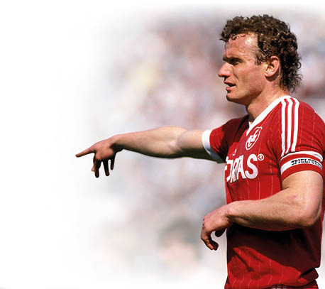 Auf dem Bild ist ein ehemaliger Fu ballspieler zu sehen, der ein rotes Trikot tr gt. Es handelt sich um Hans-Peter Briegel, genannt „Die Walz von der Pfalz“. Er war ein bekannter deutscher Spieler. Briegel zeigt mit dem rechten Arm zur Seite – vermutlich w hrend eines Spiels. Das Foto wirkt historisch, aus den 1980er Jahren.