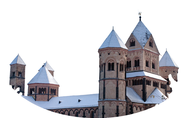 Romanische Kirche mit mehreren T rmen und schneebedecktem Dach umgeben von schneebedeckten Nadelb umen