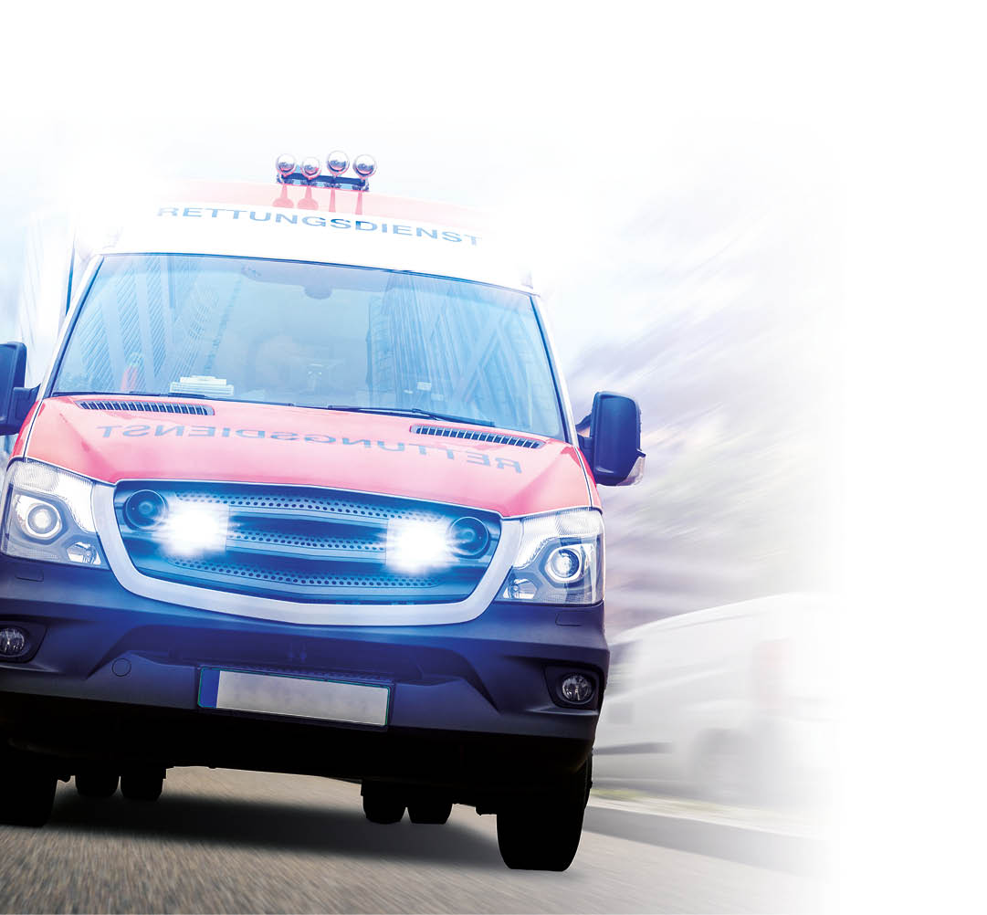 Ein Rettungswagen des DRK frontal zu sehen mit Blaulicht am K hlergrill.