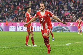 Fu ballspieler in rot-wei er Trikotierung mit ausgebreiteten Armen auf dem Spielfeld w hrend eines Spiels im Stadion