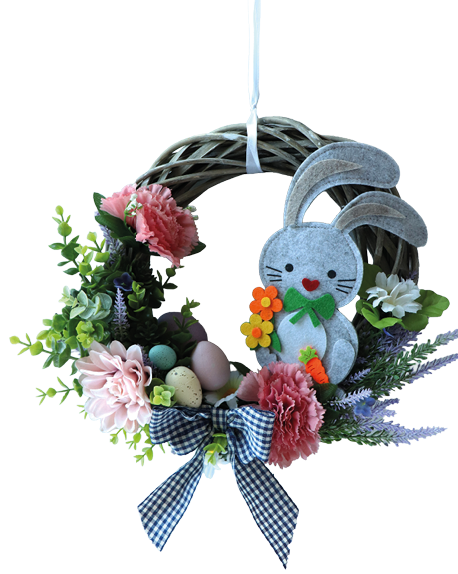 Ein runder, geflochtener Weidenkranz liegt frontal vor wei em Hintergrund. Links oben ist der Kranz mit hellgr nen Zweigen und ein paar lila Bl tenrispen geschm ckt. Unten rechts ist eine graue Filz‑Hasenfigur am Kranz befestigt. Der Hase hat schwarze Punktaugen, ein rotes herzf rmiges N schen und h lt orange‑gelbe Filzblumen sowie eine gr ne Schleife. Das Bild zeigt eine fertige, fr hlingshafte oder sterliche Dekoration ohne Personen.
