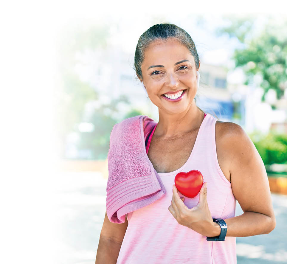 Middle age sportswoman asking for health care holding heart at the park