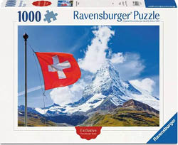 Das Bild zeigt die Vorderseite einer Puzzle‑Schachtel von „Ravensburger Puzzle“ mit der Teilezahl „1000“. In der Mitte ist ein Foto: links eine rote Schweizer Flagge mit wei em Kreuz an einem Fahnenmast, rechts dahinter ein hoher Berggipfel ( hnlich dem Matterhorn) unter blauem Himmel mit wei en Wolken. Unten im Bild liegt eine gr n‑braune Berglandschaft, die zum Gipfel hin ansteigt. Auf der Schachtel steht oben „Ravensburger Puzzle“, links oben „1000“ neben einem Puzzleteil‑Symbol. Unten ist ein rotes Siegel mit dem Wort „Exclusive“ und rechts unten ein blaues Eckfeld mit „Ravensburger“.