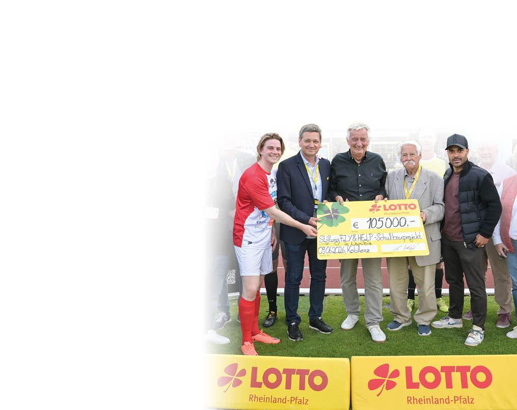 Mehrere Personen stehen auf einem Sportplatz und halten gemeinsam einen gro en symbolischen Scheck von Lotto Rheinland-Pfalz. Beschreibung von KI generiert