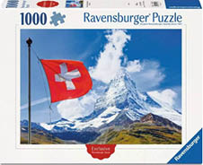 Das Bild zeigt die Vorderseite einer Puzzle‑Schachtel von „Ravensburger Puzzle“ mit der Teilezahl „1000“. In der Mitte ist ein Foto: links eine rote Schweizer Flagge mit wei em Kreuz an einem Fahnenmast, rechts dahinter ein hoher Berggipfel ( hnlich dem Matterhorn) unter blauem Himmel mit wei en Wolken. Unten im Bild liegt eine gr n‑braune Berglandschaft, die zum Gipfel hin ansteigt. Auf der Schachtel steht oben „Ravensburger Puzzle“, links oben „1000“ neben einem Puzzleteil‑Symbol. Unten ist ein rotes Siegel mit dem Wort „Exclusive“ und rechts unten ein blaues Eckfeld mit „Ravensburger“.