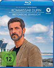 Ein Erwachsener mit kurzem dunklem Haar und Bart tr gt eine braune Jacke und steht vor einer K stenlandschaft mit einem Haus und blauem Himmel im Hintergrund, auf dem Blu-ray-Cover von Kommissar Dupin Bretonische Sehnsucht. Beschreibung von KI generiert
