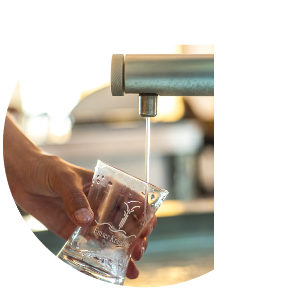 Wasser flie t aus einem Metallhahn in ein schr g gehaltenes Glas. Beschreibung von KI generiert